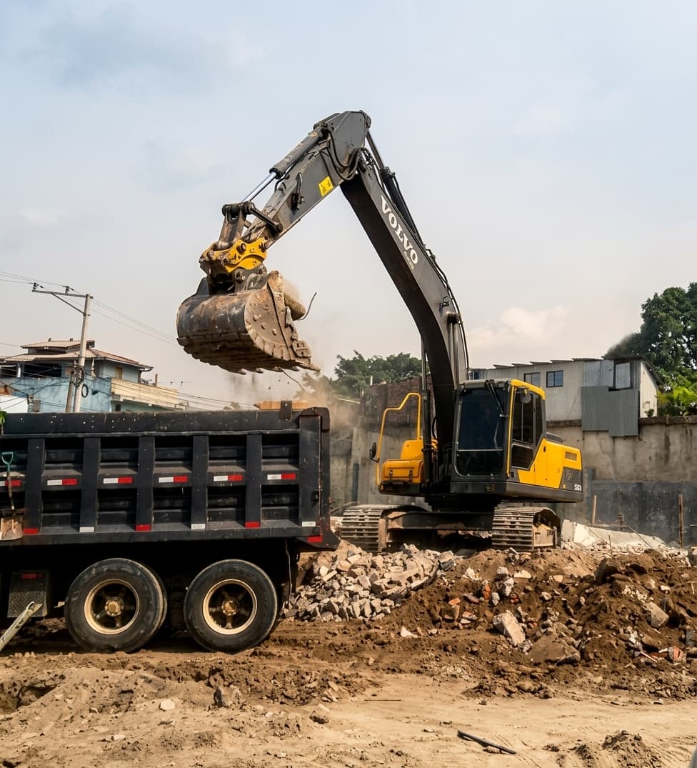 Excavadora cargando escombros y ripio en camión de volteo para desalojo de material